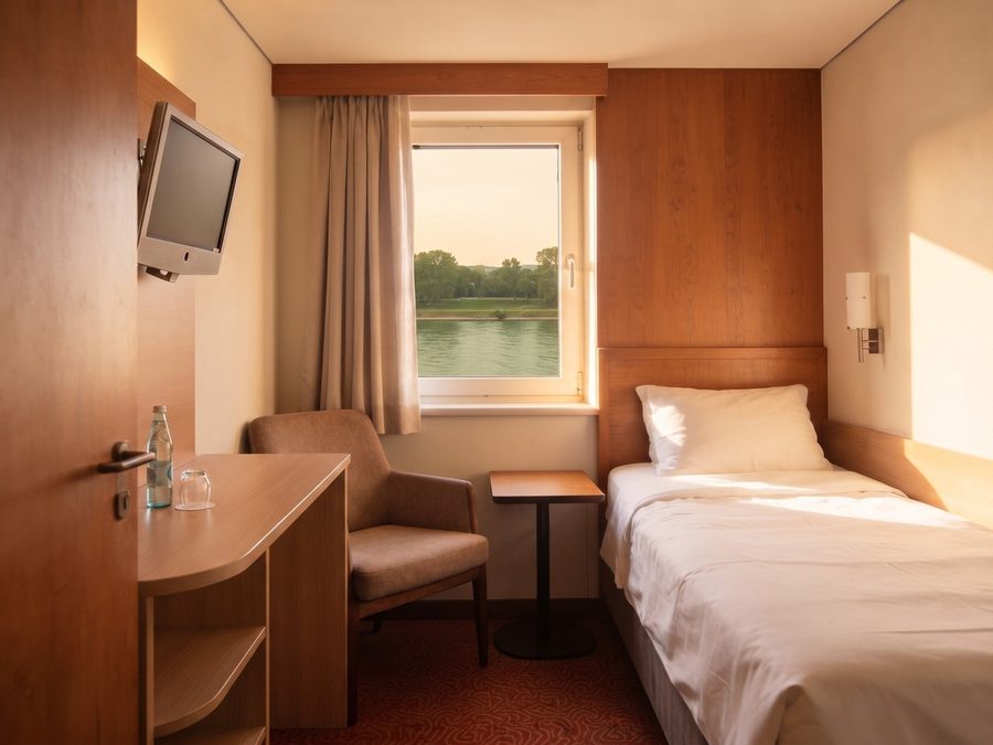Einzelzimmer mit Bett, kleinem Schreibtisch und Fenster zur Tauber