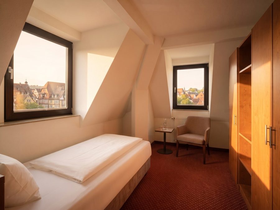 Einzelzimmer unter der Dachschräge mit Sessel und Blick auf die Altstadt